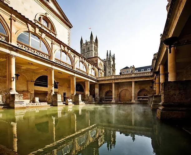 View of hot springs and abbey on a sunny day in Bath, England